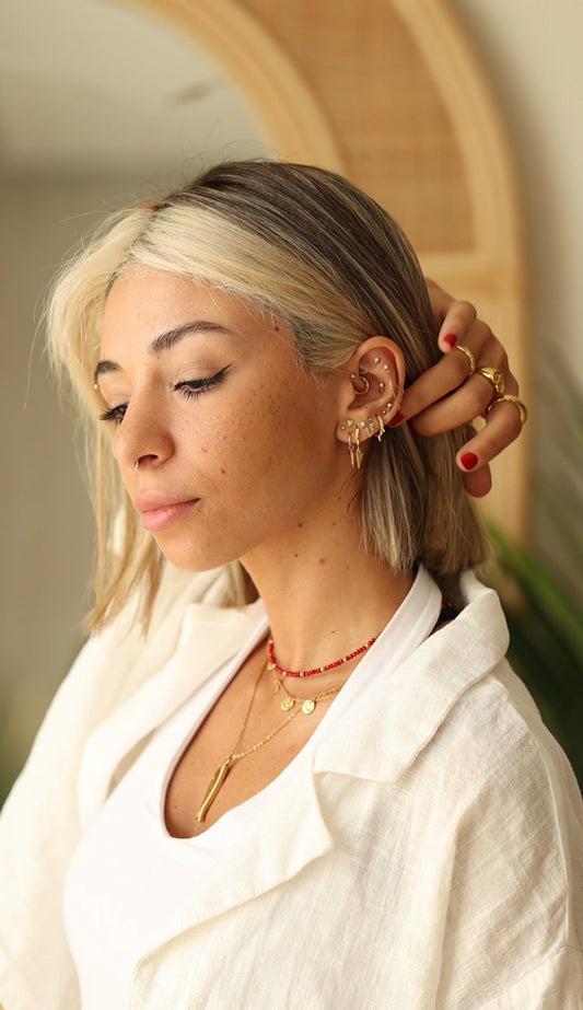 Client wearing a curated ear with layered necklaces